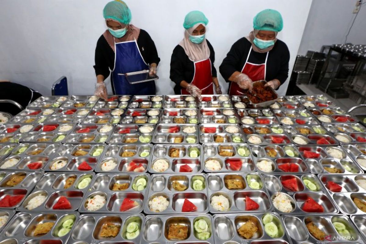Petugas menyiapkan makanan dalam Program Makan Bergizi Gratis di dapur layanan gizi pemerintah.